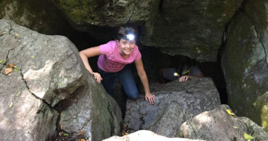 young girl climbing out of cave